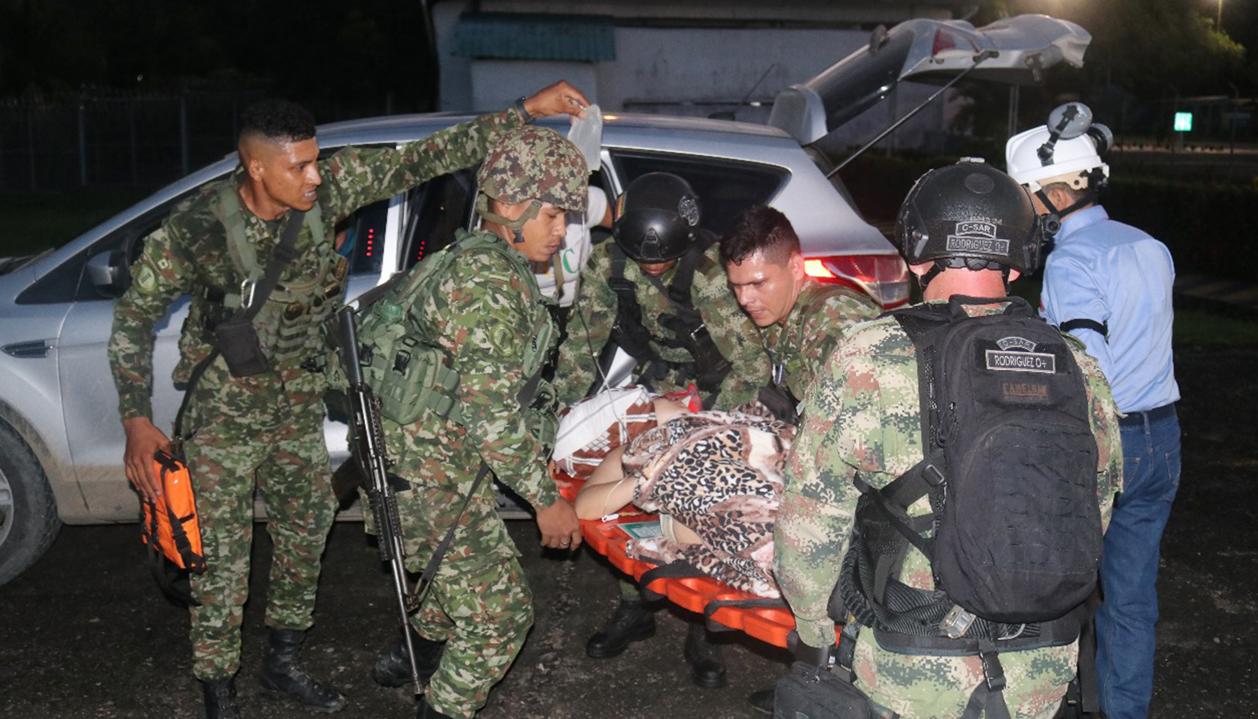 Integrantes de las Fuerzas Militares trasladando a una persona herida este jueves.