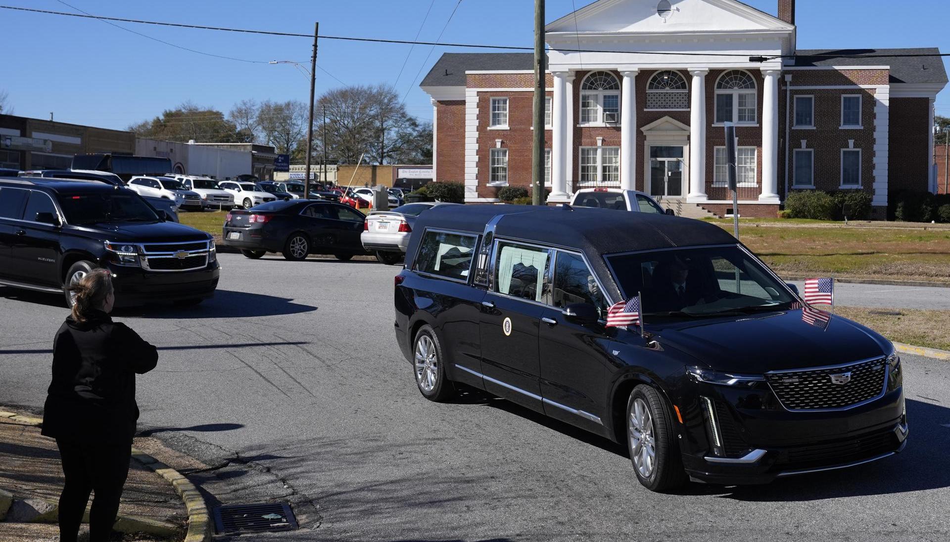 Paso del coche fúnebre que transporta el ataúd del expresidente de EE.UU. Jimmy Carter.