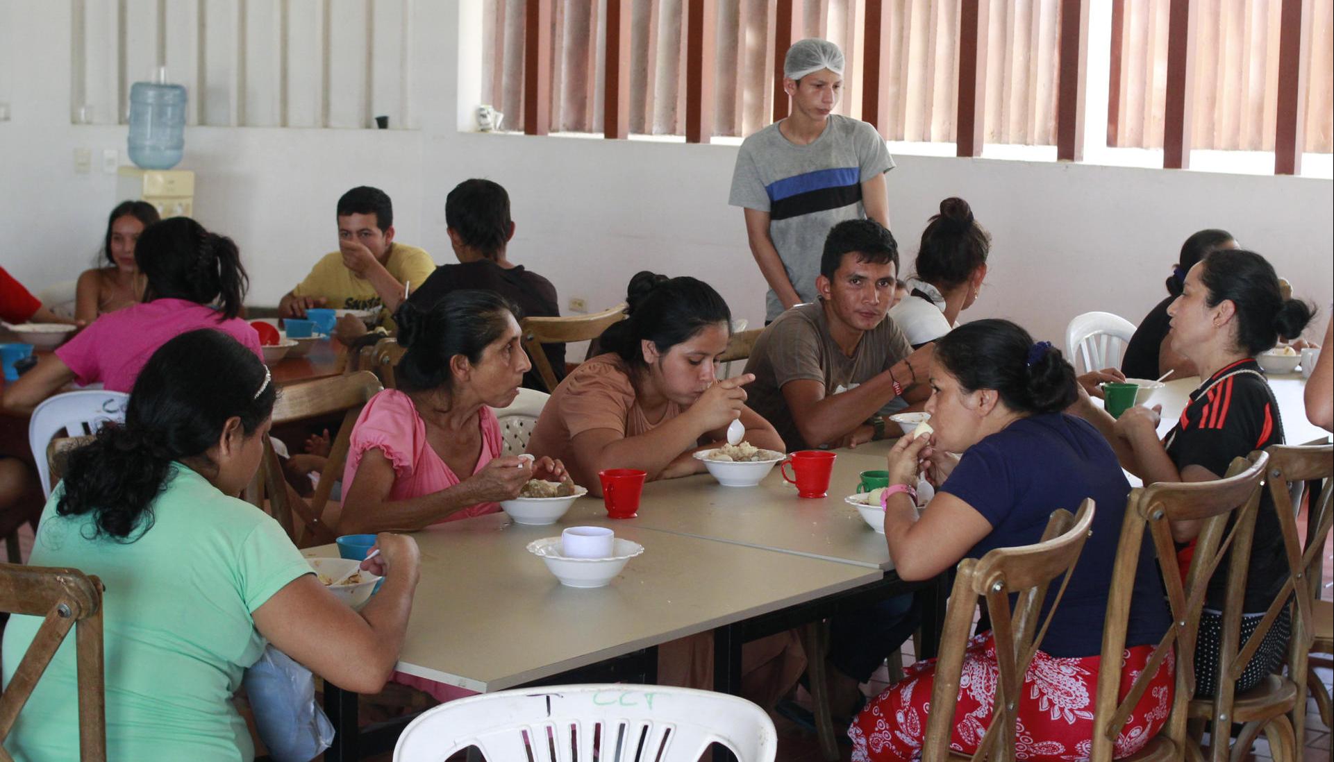 Varias personas comen en el Albergue del Seminario Menor en Tibú.