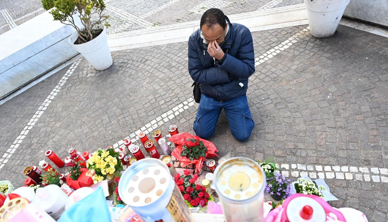 Un hombre reza junto a la estatua de Juan Pablo II en el hospital Gemelli, en Roma.