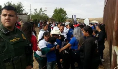 Los miembros de una familia se reencuentran por cuatro minutos frente al muro fronterizo entre Estados Unidos y México, en Sunland Park (Estados Unidos).