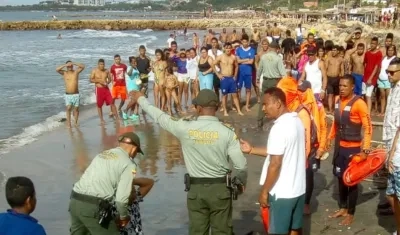 Un policía consuela a un familiar de la joven ahogada en Sabanilla.
