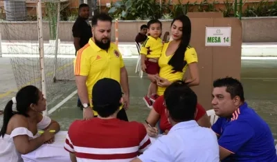 Una familia vota ataviada con los colores de la Selección Colombia.