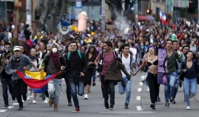 Cientos de personas marchan este lunes, durante el quinto día de protestas, en el marco del Día Internacional de la Eliminación de la Violencia contra la Mujer, en Bogotá (Colombia). 