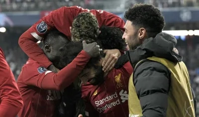 Jugadores del Liverpool celebran con Mohamed Salah una anotación. 