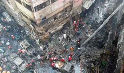 Varios bomberos inspeccionan los escombros tras el incendio declarado en la madrugada de este jueves en el barrio Chawkbazar del casco viejo de Dacca (Bangladesh).
