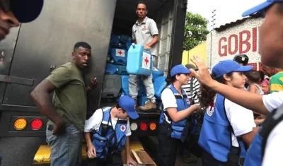 Voluntarios de la Cruz Roja entregando ayudas a los necesitados y abandonados venezolanos.