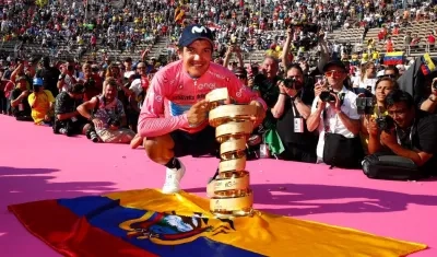 Richard Carapaz con el trofeo y la bandera de su natal Ecuador. 
