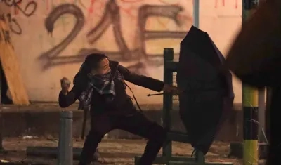 Un manifestante se enfrenta con integrantes del Escuadrón Móvil Antidisturbios (Esmad)