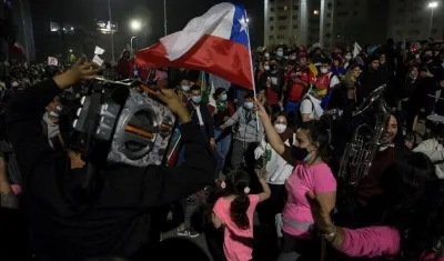 Mujer sostiene la bandera de Chile, durante los festejos del triunfo del plebiscito. 