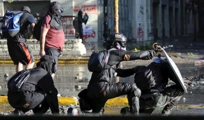 Manifestantes enfrentan a los carabineros durante una nueva jornada de protestas antigubernamentales en Santiago (Chile).