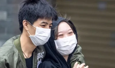 Pareja de novios en China protegiéndose con tapabocas del coronavirus.