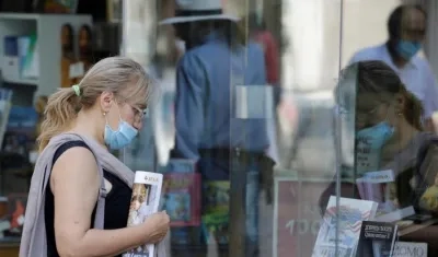Una mujer usando incorrectamente el tapaboca en una calle del país.