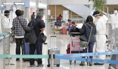 Personal del aeropuerto internacional de Incheon, al este de Seúl, comprueban que los pasajeros que llegan, lo hacen con una PCR negativa. 