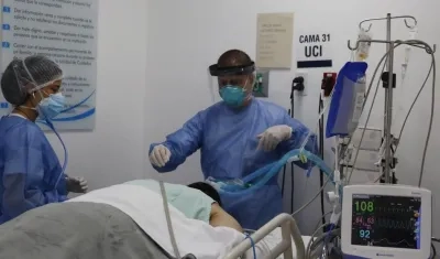 Empleados de la salud atienden a un paciente en la unidad de cuidados intensivos para enfermos de Covid-19 en la Clínica CES, en Medellín.