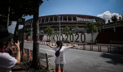 Dos mujeres se toman fotos en los alrededores del Estadio Olímpico de Tokio