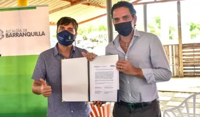 El Alcalde Jaime Pumarejo y el Gerente de la Triple A, Jairo De Castro, con el documento de cesión.