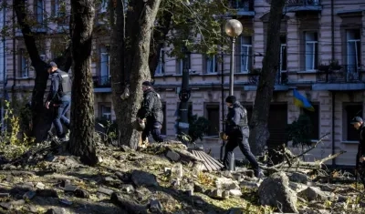 Agentes de policía caminan entre los escombros tras un bombardeo en el centro de Kiev este lunes. 