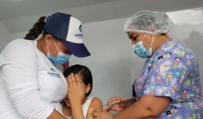 Una funcionaria de salud vacuna a una niña sucreña contra Covid-19.