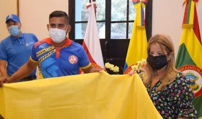 Candelario Donado recibe la bandera de Colombia de la gobernadora Elsa Noguera. 