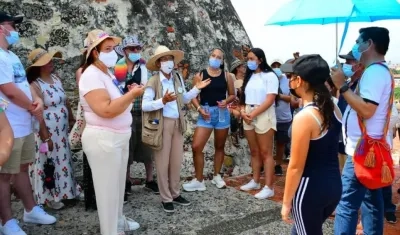 Turistas escuchan a una guía en el Castillo de San Felipe.