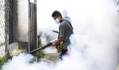 un habitante de El Salvador durante una jornada de fumigación para erradicar criaderos de mosquitos transmisores del dengue.