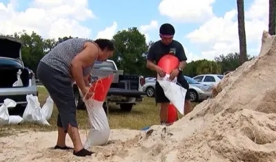 Habitantes de Tampa llenan sacos de arena para protegerse de las inundaciones.