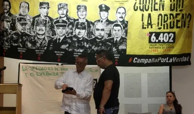  El coronel (r) Jaime Humberto Pinzón entrega una medalla otorgada por sus actuaciones militares hace 18 años a José Alexander Castro, del colectivo Tejiendo Memorias.