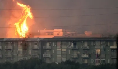 Columna de fuego se eleva tras un bloque de viviendas en el área de Monte Grifone, en Italia.