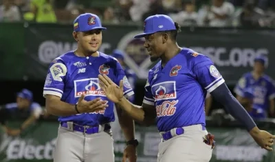 Jesús Marriaga, el pelotero más destacado de Caimanes en el juego, recibe el saludo del mánager Carlos Vidal.