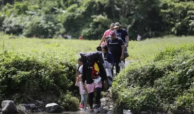  Migrantes acompañados con niños pequeños mientras caminan el Darién