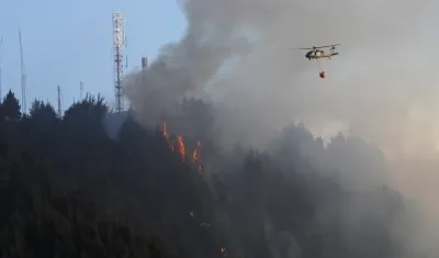 Un helicóptero combate un incendio forestal en el cerro El Cable, en Bogotá.